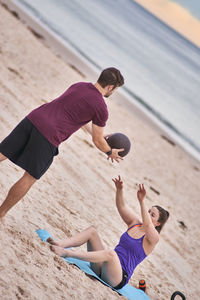 Young friends exercising at beach