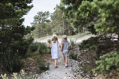 Rear view of women walking in forest