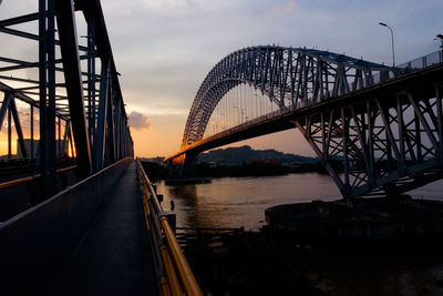 Bridge over river against sky during sunset