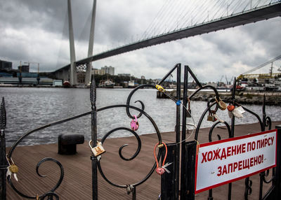 Bridge over river in city against sky