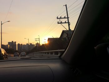 Cars on street in city during sunset