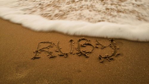 Close-up of text on sand