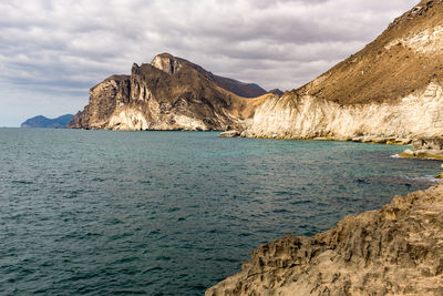 Scenic view of sea and mountains against sky