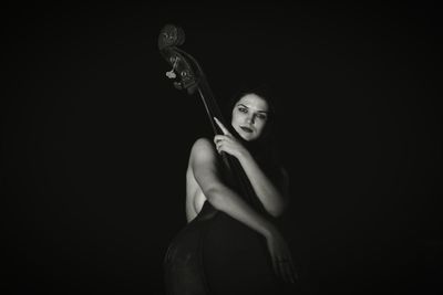 Portrait of woman with double bass in darkroom