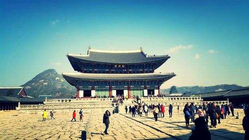 Tourist visiting temple against clear sky