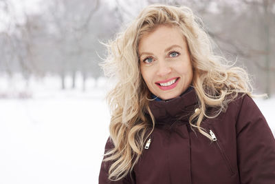 Portrait of smiling woman in snow