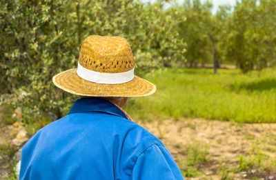 Rear view of man wearing hat against trees