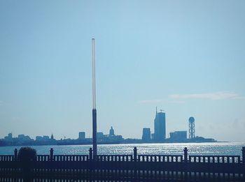 City at waterfront against clear sky