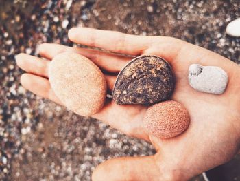 Close-up of hand holding pebbles