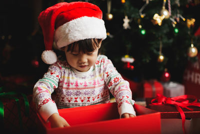 Girl looking in christmas present at home