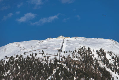 Snow covered mountain against blue sky