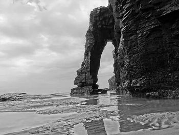 Rock formations against cloudy sky