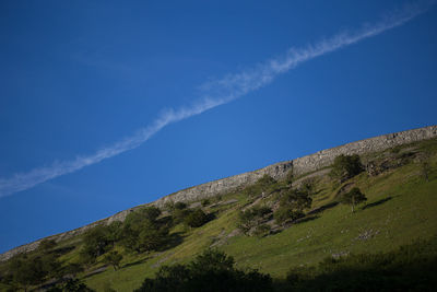 Low angle view of mountain against blue sky