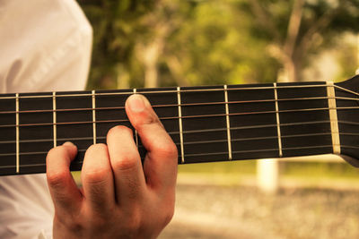 Midsection of man playing guitar