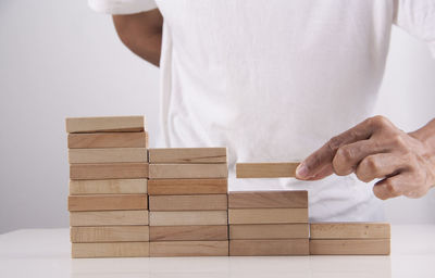 Close-up of man playing on table against white background