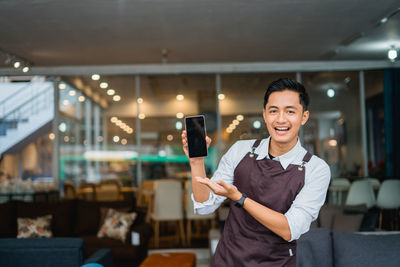 Young woman using mobile phone in cafe