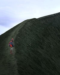 Rear view of woman on mountain against sky