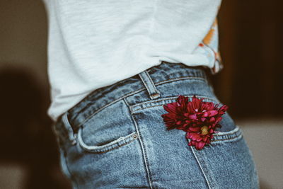 Midsection of woman standing against red wall