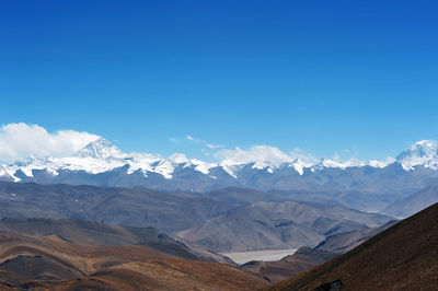 Scenic view of snowcapped mountains against blue sky