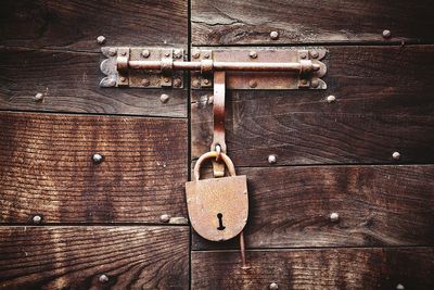 Close-up of rusty lock on wooden door