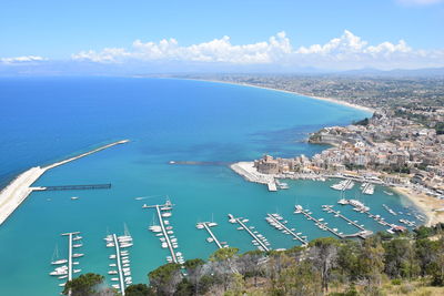 High angle view of sea by cityscape against sky