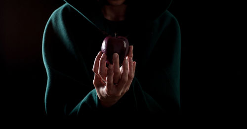 Midsection of woman holding apple over white background