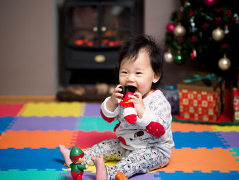 Portrait of cute baby girl playing with toy at home during christmas