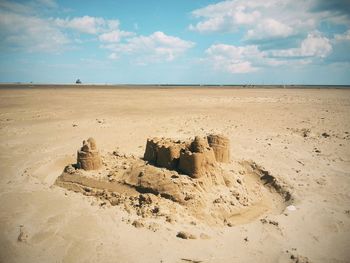 Sandcastle on beach against sky