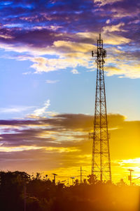 Low angle view of communications tower against sky during sunset