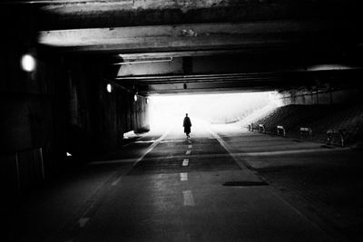 Rear view of man walking in subway tunnel