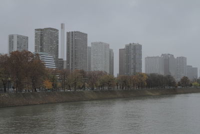 River by buildings against sky in city