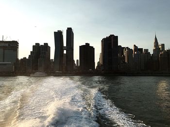 River in front of cityscape against sky