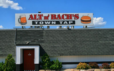 Low angle view of sign on building against sky