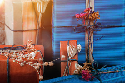 Close-up of flowers with gift on table at home