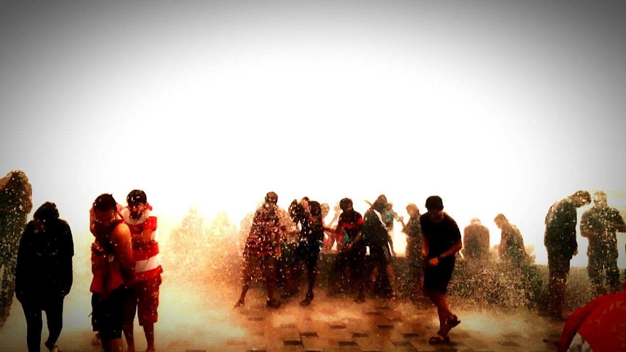 PEOPLE STANDING IN FRONT OF CROWD AGAINST CLEAR SKY DURING WINTER