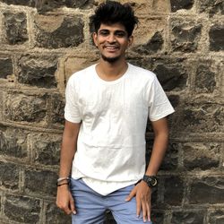 Portrait of young man standing against wall