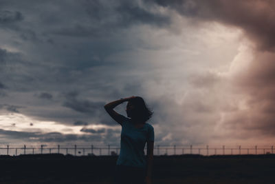 Woman standing against sky during sunset