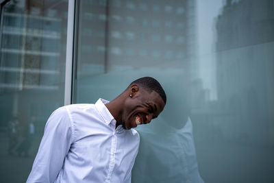 Side view of man looking through window