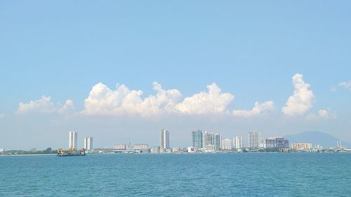 Panoramic view of sea and buildings against sky