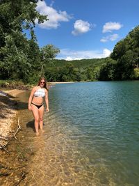 Portrait of teenage girl in bikini standing at lake