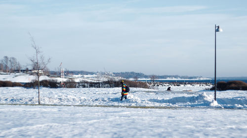 Man on snow covered land against sky