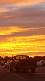 Cars on road against orange sky