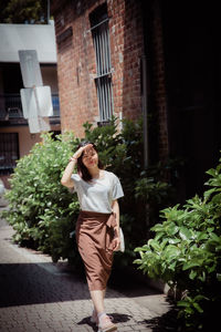 Full length rear view of woman standing against building