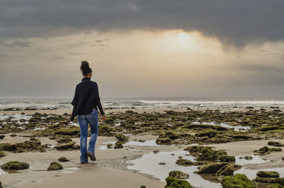 Rear view of man standing on beach