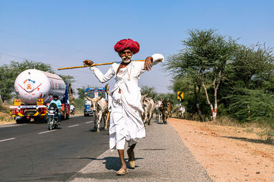 Rear view of man walking on road