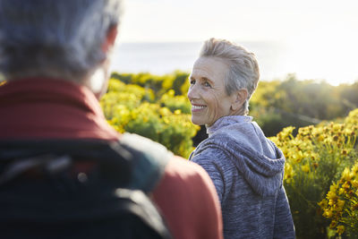 Smiling woman looking at man while standing outdoors