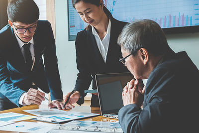 Colleagues working over graph in office