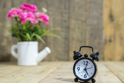 Close-up of clock on table against wall