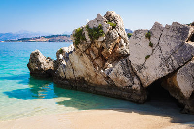 Rock formations in sea against clear sky