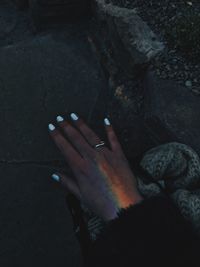 Close-up of woman hand on rock at night